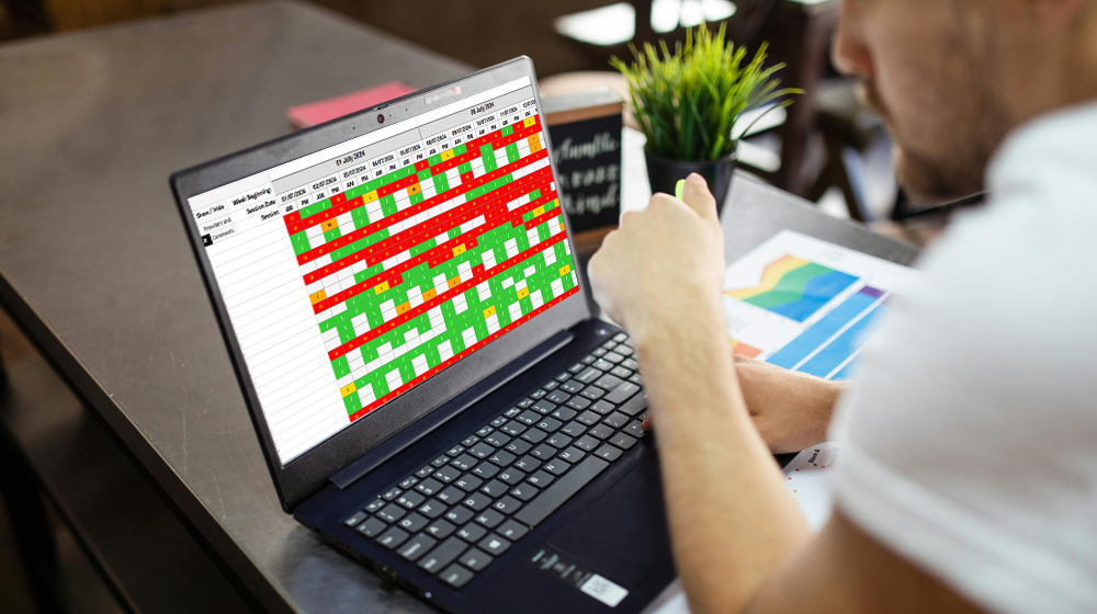 A teacher using a laptop, you can see an attendance report on the screen as part of the Alternative Provision Attendance system.