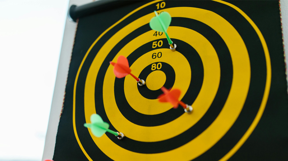 Multiple darts hitting a target. A representation of targets and frameworks within Alternative Provision Attendance system.